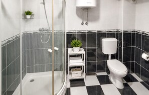 A bathroom with a shower enclosure, a toilet, a sink, and a small potted plant. - Nice apartment in Vrgorac with swimming pool (Vrgorac)