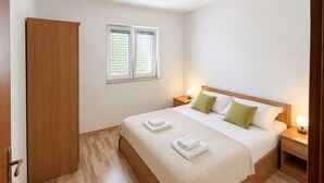 A hotel room with a bed, two bedside tables, a wardrobe, and a window with blinds. - 6 bedroom pet friendly apartment in Vrgorac (Vrgorac)