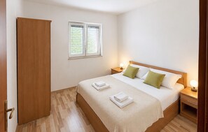 A hotel room with a bed, two bedside tables, a wardrobe, and a window with blinds. - 6 bedroom pet friendly apartment in Vrgorac (Vrgorac)