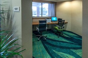 A business library room with two desks, chairs, and a large window.