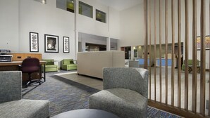 Eine großzügige Lobby mit Empfangsschalter, Sitzgelegenheiten und einem großen Fenster.