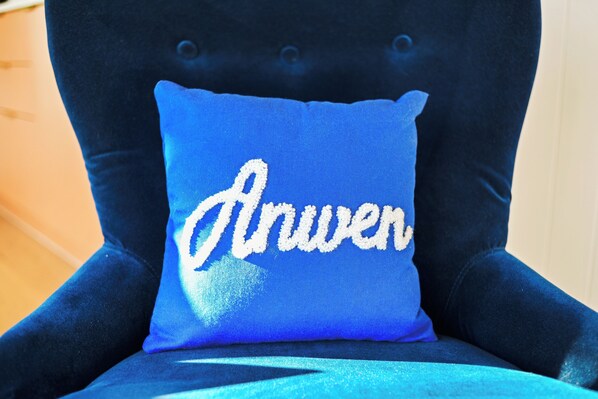 Une chaise avec un coussin bleu orné d’un motif brodé.