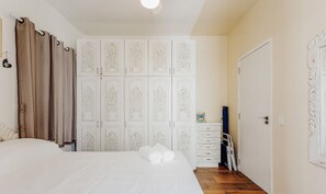 Ein Schlafzimmer mit einem Bett, einem Schrank mit aufwendigen Verzierungen und einer Kommode mit Schubladen.