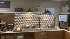 Un espace dédié au petit-déjeuner, doté d’un mur recouvert de marbre, d’une machine à café et d’un distributeur d’eau.