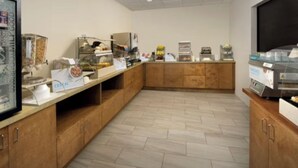 Espaço de café da manhã com balcão, cereais à mostra e máquina de café.