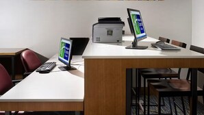 Et moderne kontor med to computorskærme, en printer samt et skrivebord med tastatur og mus.