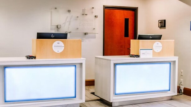Et receptionområde med to bemandede diske, hver med et digitalt display og skilte der angiver 'Express'-services.