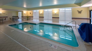 En indendørs swimmingpool med en dybdemarkering på 3 fod, en vægdekoration i sommerfugleform og et forbudsskilt mod dykning.
