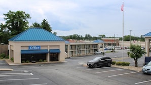 A parking lot with a building labeled "Office" and a "HAPPY LOBBY" sign in the background. - Affordable Stay Near Liberty University with Free Breakfast & Outdoor Pool (Lynchburg)