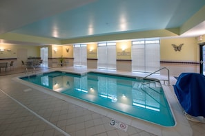 Piscina interior com marcação de profundidade de 3 pés, decoração de parede em formato de borboleta e placa de proibição de mergulho.