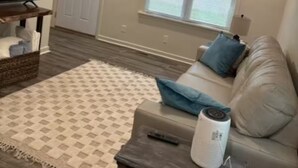 A living room with a television, a sofa, a patterned rug, and a ceiling fan. - Clay Street Retreat Entire home in Clinton, Illinois (Clinton)