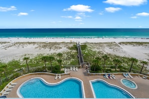 Un complexe hôtelier doté de deux piscines, d’une plage et d  ’une promenade qui mène à la plage.