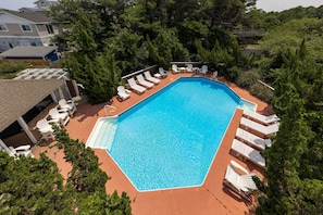 A rectangular swimming pool with a clear blue water surface, surrounded by white lounge chairs and deck chairs. - 9BR Sandbridge beach home with pool, hot tub, and game room (Virginia Beach)