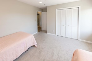 A bedroom with a single bed, a closet, and a door leading to another room. - 9BR Sandbridge beach home with pool, hot tub, and game room (Virginia Beach)