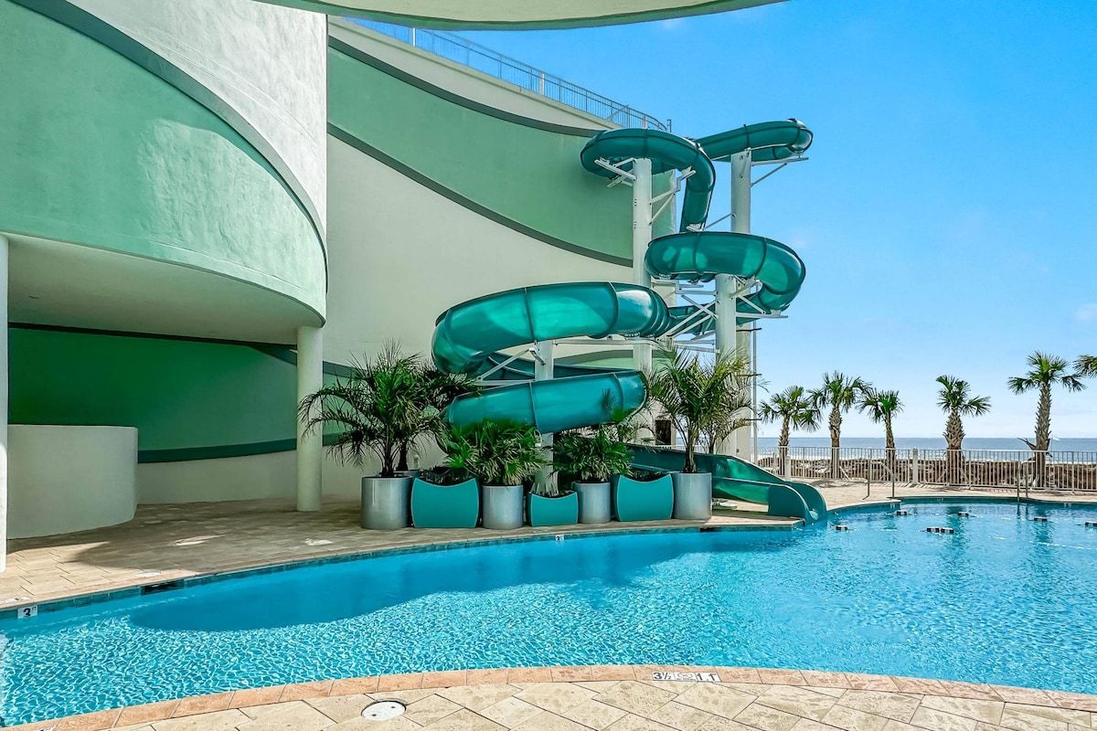 A swimming pool with a water slide structure.