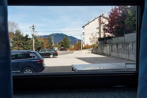 A parking lot with cars, a building, and mountains in the background.