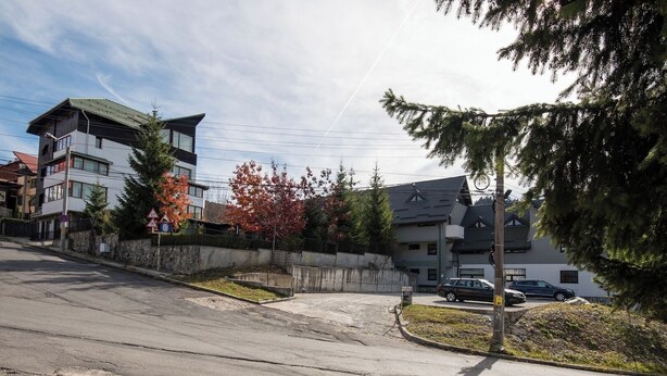 A residential street with modern houses, a clear sky, and autumn foliage. - Sia Mountain Apartment (Predeal)
