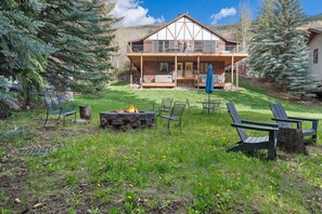 A lodge with a wooden exterior, a deck, and outdoor seating. - 3BR West Vail riverfront duplex, hot tub, fireplace, yard (Vail)
