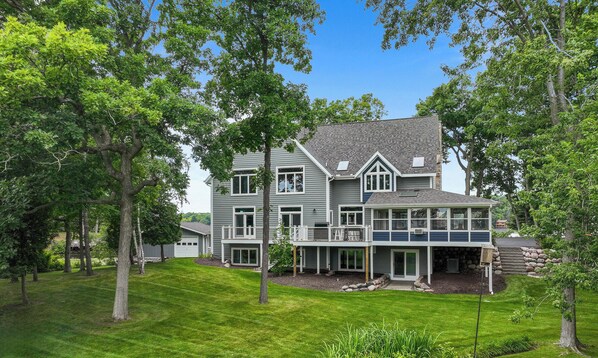 A two-story house with a garage, a covered porch, and a stone staircase leading to the entrance.