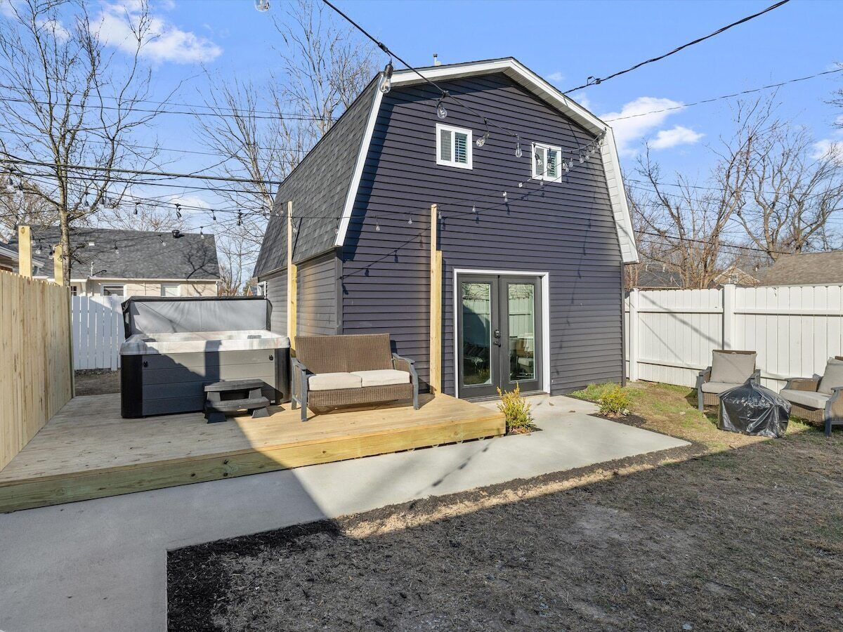 A residential property with a covered patio, a hot tub, and a wooden deck.