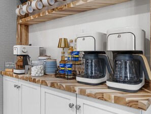 A kitchen counter with two coffee makers, a coffee machine, a lamp, and various kitchen items.
