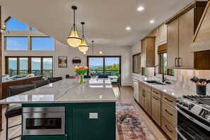 A modern kitchen with a large island, stainless steel appliances, and a view to the outdoors. - Ridge & Repeat Lodge at Eagles Nest - hot tub, in+out fireplace, firepit, views (Banner Elk)