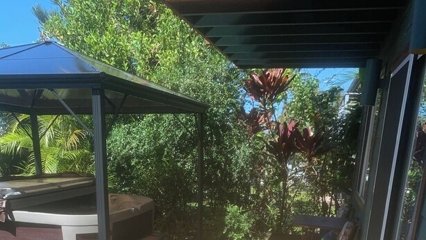 Un'area esterna riparata con tavolo e sedie da patio, immersa nel verde.