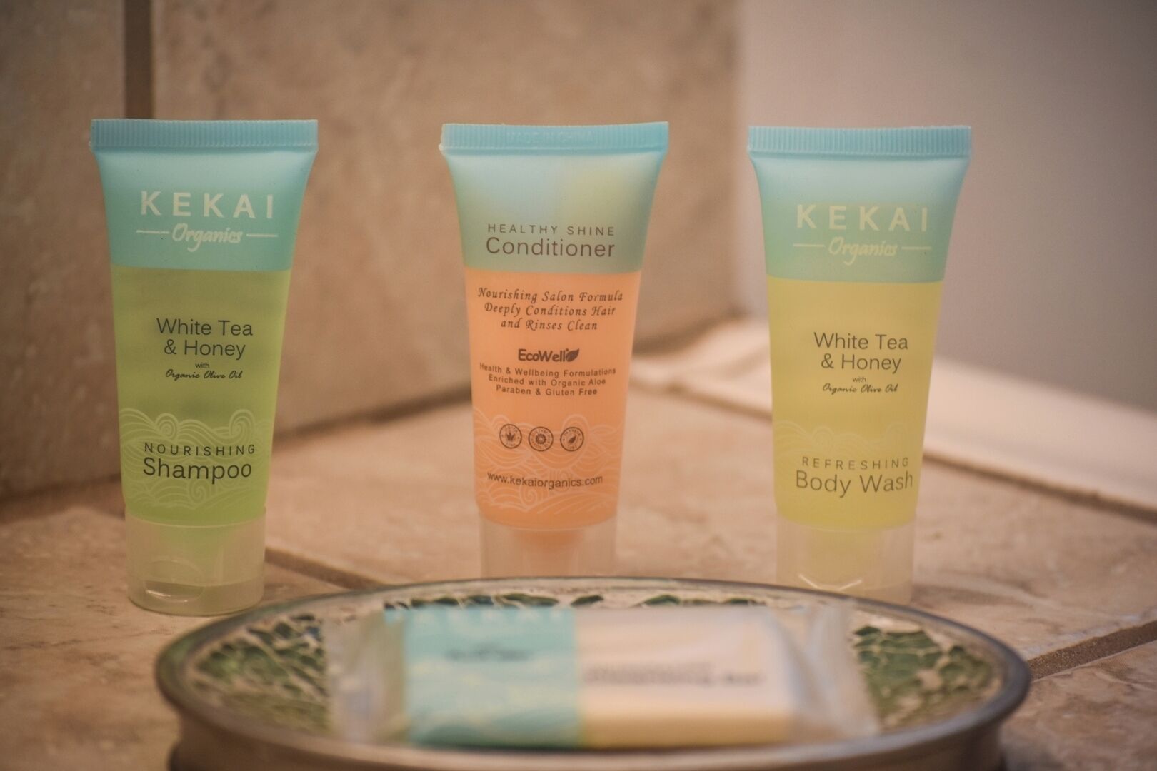 Three skincare products from KEKAI Organics on a tiled surface.