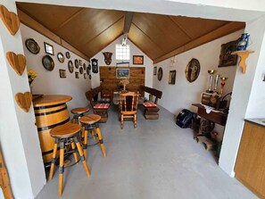 Una habitació acollidora amb sostre de fusta, una taula de dinar amb cadires i diverses imatges emmarcades a les parets.