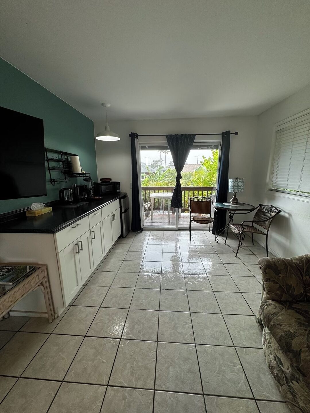 A kitchen with a dining area, a TV, and a view of the outdoors.