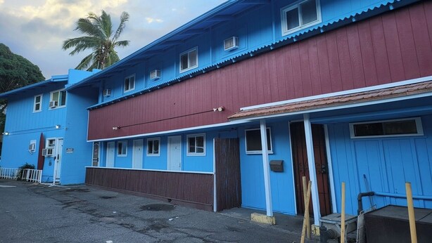 Un edificio de dos plantas con fachada azul y sección inferior roja.