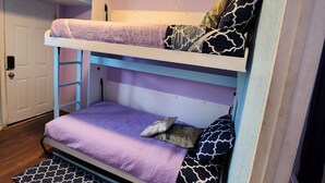 Una litera con una cama inferior y una puerta a la izquierda.