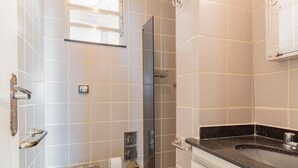 Un baño con ducha, inodoro, lavabo y ventana.