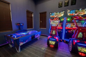 A room with a pool table, arcade machines, and a wall with framed artwork. - Soak Up the Sun! Luxury 8BR Villa & South Pool (Kissimmee)