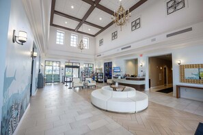 A spacious lobby with a reception desk, seating area, and a large window allowing natural light. - Soak Up the Sun! Luxury 8BR Villa & South Pool (Kissimmee)