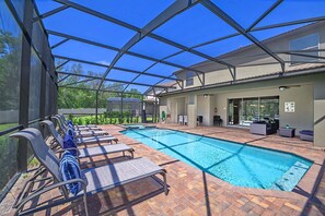 Piscina ao ar livre coberta com espreguiçadeiras e um espaço de terraço.