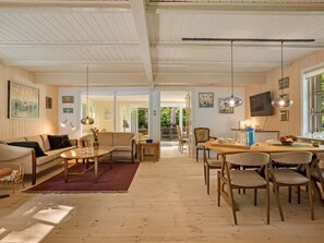 Ein geräumiges Wohnzimmer mit Sofa, Couchtisch und Essbereich.