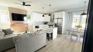 A modern kitchen with white cabinets, a built-in oven, and a stainless steel refrigerator. - The Clark House St. Augustine (Saint Augustine)