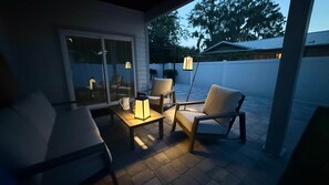 An outdoor patio area with a seating arrangement, including a table and chairs, and a lamp post. - The Clark House St. Augustine (Saint Augustine)