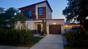 Ein modernes, zweistöckiges Haus mit Garage, gepflegtem Rasen und Auffahrt.