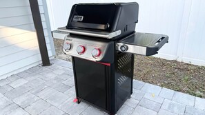 A portable gas grill with a control panel, a side burner, and a storage compartment. - The Clark House St. Augustine (Saint Augustine)