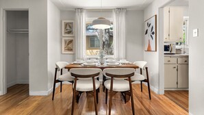 A dining room with a wooden table set for four, surrounded by chairs, with a pendant light above. - Dog-Friendly Arvada Home with Fire Pit, 18 Min to Red Rocks & Near Denver (Arvada)