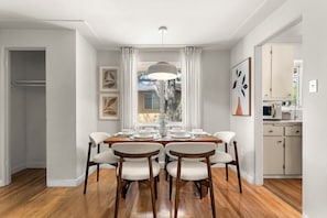 A dining room with a wooden table set for four, surrounded by chairs, with a pendant light above. - Dog-Friendly Arvada Home with Fire Pit, 18 Min to Red Rocks & Near Denver (Arvada)