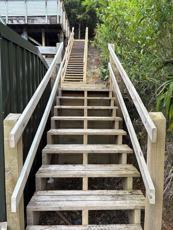 Una escalera de madera con barandillas de metal que conduce a un edificio.