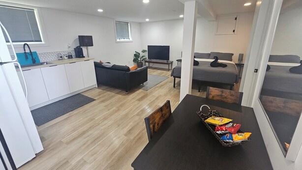 A modern apartment with a kitchen, dining area, living room, and a bedroom.