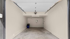 A clean, empty hallway with a grey floor, white walls, and a ceiling with recessed lighting. - Spring Creek Vacations 4 BR Villa TMV18 (Canmore)