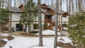 A lodge with a central staircase, surrounded by trees and snow. - Slopeside Boyne Mountain Retreat (Boyne Falls)