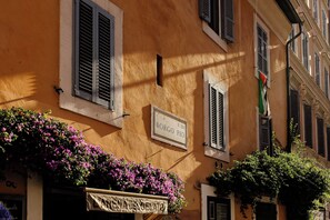A building with a sign reading 'BORGO PIO R.XIV' and a balcony with purple flowers. - Residenza Porta Castello (4 guests) – Elegant Retreat in San Pietro/Vatican City (Roma)