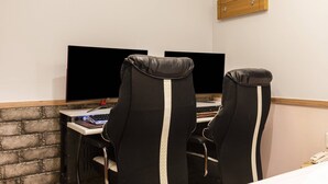 A workspace with two monitors, a laptop, and two black office chairs with white stripes. - Yeongdeungpo Komodo Hotel (Seoul)