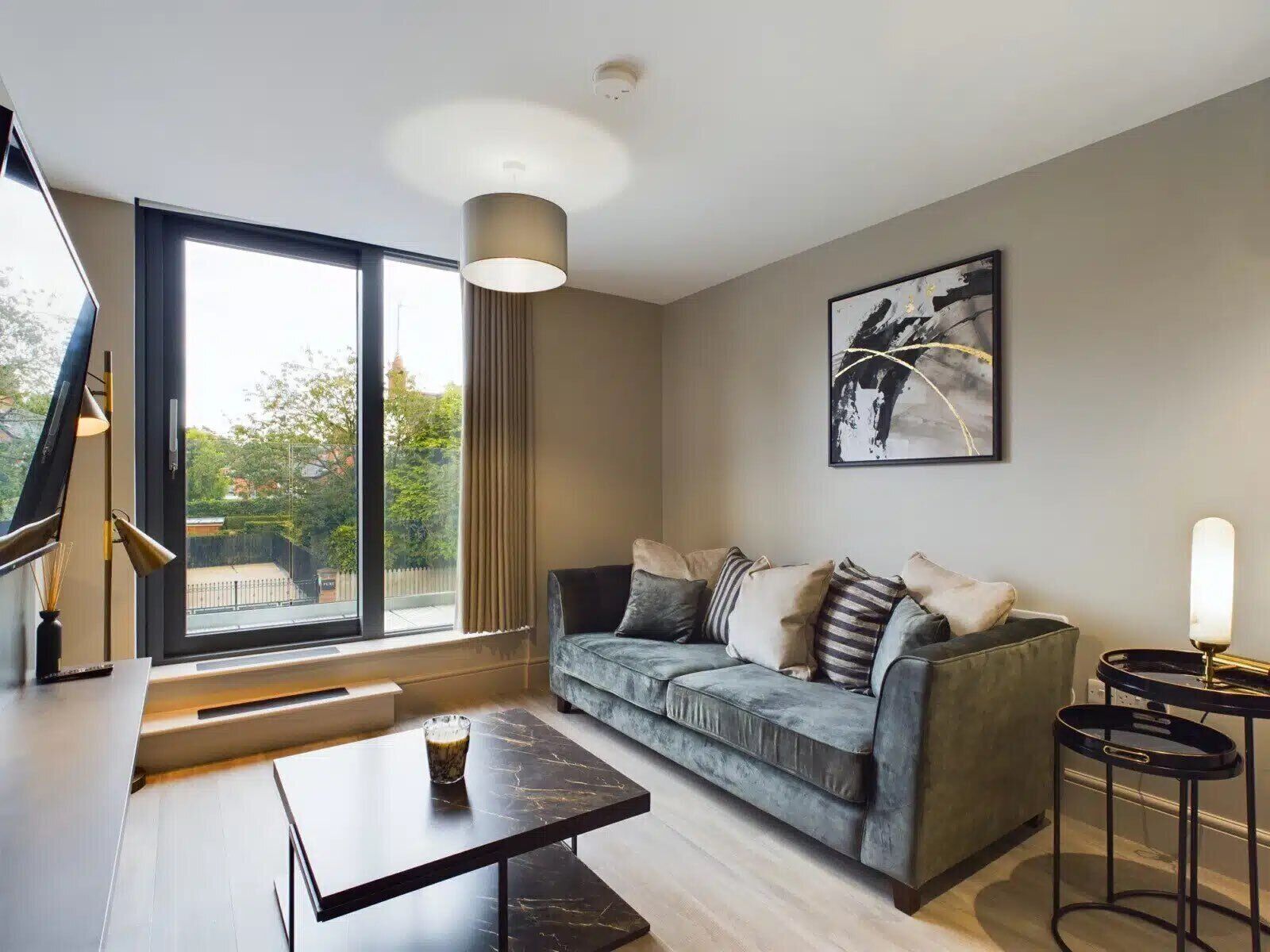 Een moderne woonkamer met een bank, een salontafel en een groot raam.